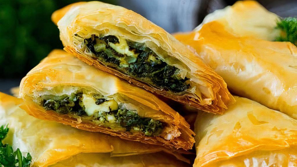 Spanakopita  · Chopped spinach, diced onions and feta cheese, served in a flaky puffed shell with house dressing.