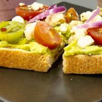 Avocado Toast · Avocado spread over sourdough bread, topped with feta cheese, cherry tomatoes and red pepper...