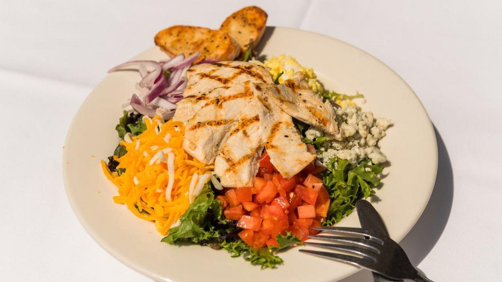 Cobb Salad · Grilled chicken, chopped eggs, red onion, diced smoked bacon, diced tomatoes, crumbled bleu cheese, shredded mixed cheese, spring mix and served with your choice of dressing.