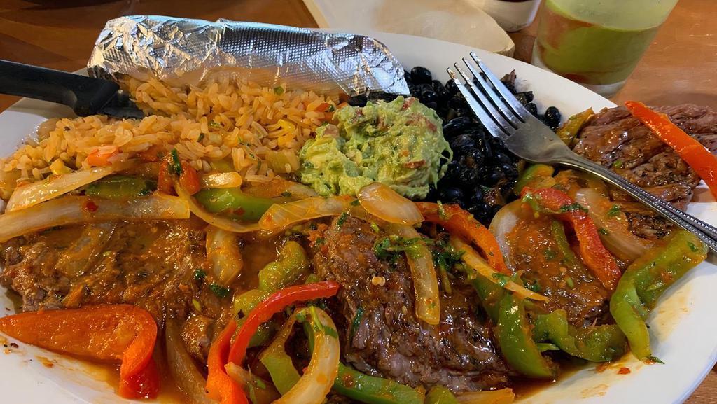 Carne Asada · Grilled skirt steak, Mexican white rice, beans, fajita vegetables, guacamole, grilled jalapeño and onions. Tortillas on the side.