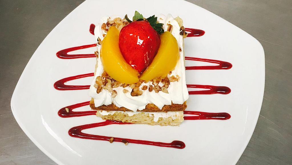 Tres Leches Cake · Sponge cake dipped into our signature three leches, topped with whipped cream, strawberries, and pecans.