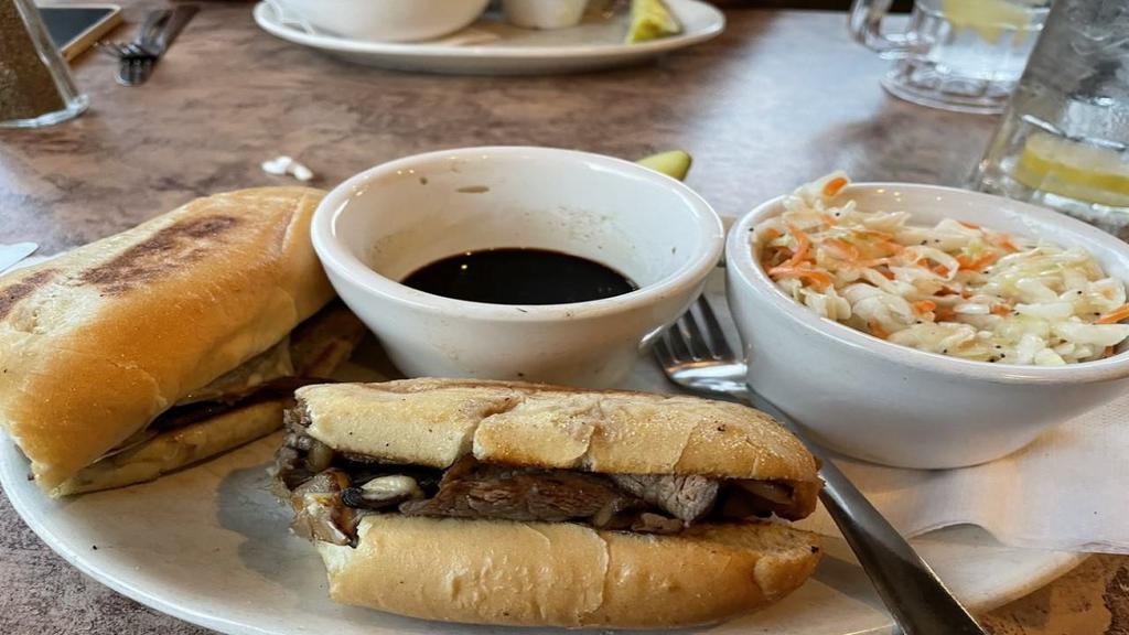 French Dip · Thin sliced roast beef grilled topped with mushrooms, onions and provolone cheese on a toasted bun with a side of fries and au jus.