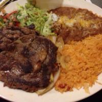 Carne Asada · Rib eye steak with grilled onions on top. served with lettuce, pico de gallo, sour cream, ri...