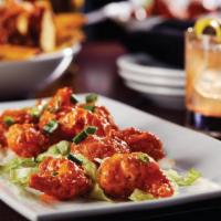 Boom Boom Shrimp · Crispy shrimp tossed in a sweet and spicy sauce. Served over a bed of shredded lettuce and t...