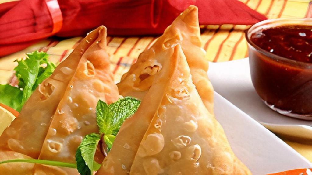 Vegetable Samosa (2 Pcs) · Vegetable (potatoes and green peas) fillings seasoned with  Nepali spices hand-wrapped in fresh dough, all made from scratch and served with delicious tamarind sauce.