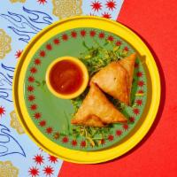 Vegetable Samosas · Two samosas filled with seasoned potatoes and peas and wrapped in a light pastry.