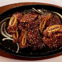 La Short Ribs · Served with Rice and Bonchon on a hot plate under bed of onions.