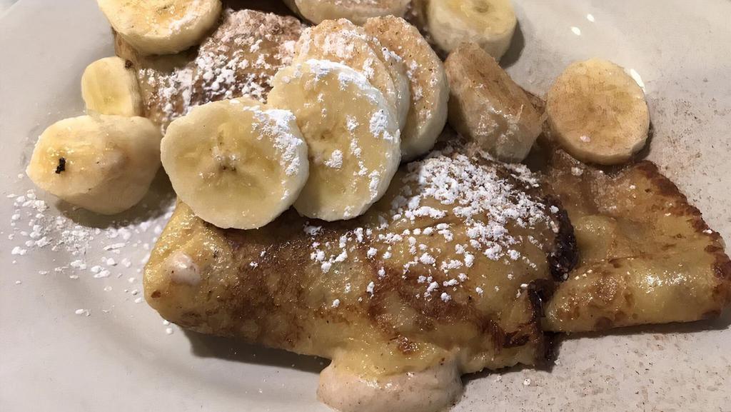 Banana Cream Cheese Crepes · Two delicate cinnamon cream cheese crepes with fresh banana slices and cream cheese.