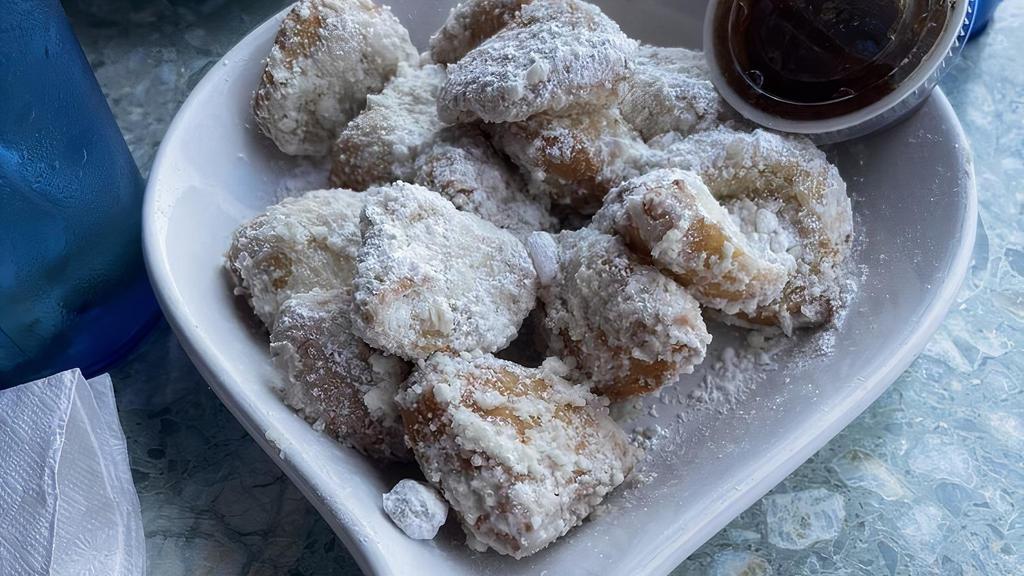Art’S Famous Fried Biscuits · Crisp on the outside, warm and flakey on the inside, served southern style with powdered sugar and honey marmalade.