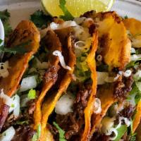Street Tacos · Three tacos on a corn tortilla with cilantro, onions, lime, and a hot sauce on the side. Ser...