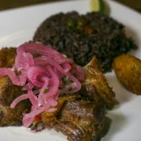 Masas De Puerco · Slow fried pork, pickled red onion, and chimichurri rojo. Served with congrí.