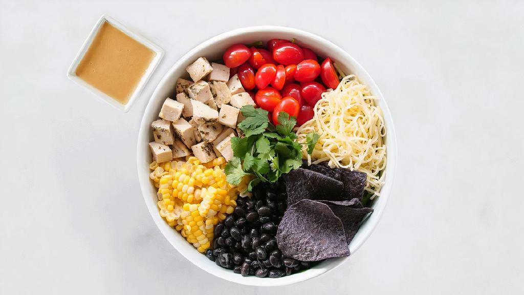 Wild Wild Southwest · Arugula, spinach, roasted chicken, roasted corn, black beans, white Cheddar, tomatoes, cilantro, blue corn chips, and creamy Southwestern dressing.