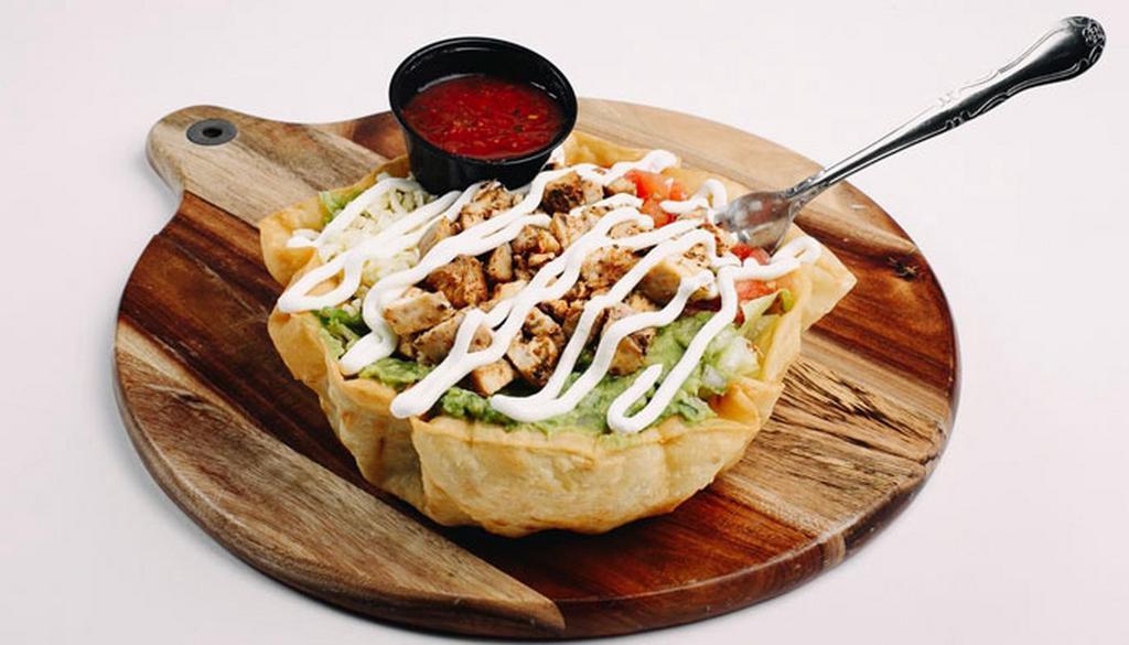 Yabo'S Taco Salad · Fresh cut Romaine lettuce in crispy tortilla bowl topped with guacamole, sour cream, pico de gallo, shredded cheese and your choice of protein