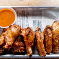 Smoked Wings · a pound of house-smoked wings served naked or tossed in your choice of sauce.