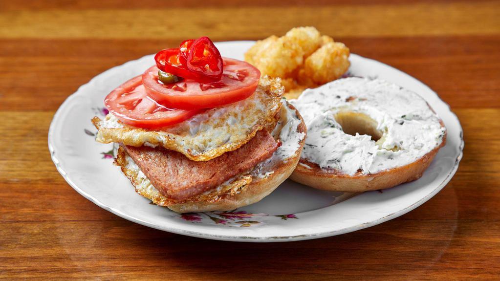 #Baegoal · Bagel sandwich filled with an over easy eggs, lemon herb cream cheese, tomato & with your choice of house bacon or spam. Served with tater tots. *Vegetarian option comes with no meat