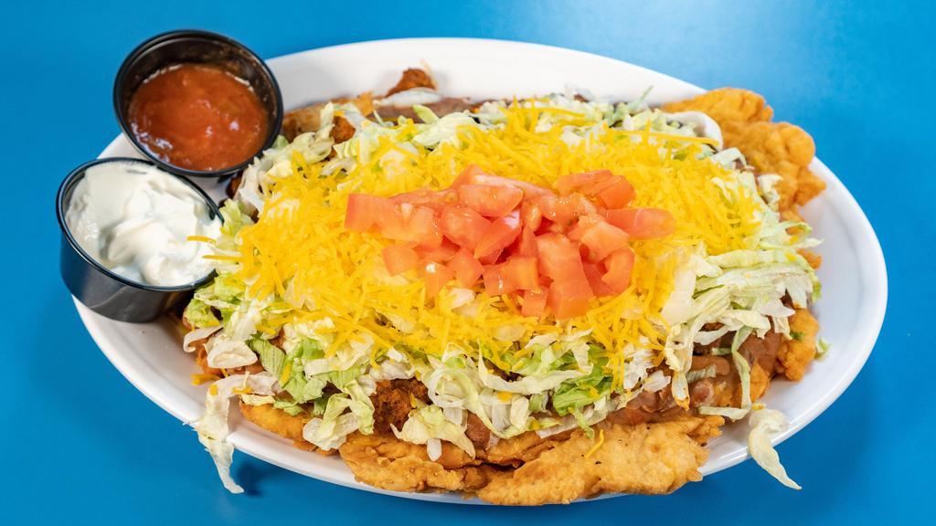 Indian Taco · Homemade Fry Bread Topped with Our Delicious Chili and Bean, Onions, Lettuce, Grated Cheese, Diced Tomatoes, Served with Salsa, and Sour Cream