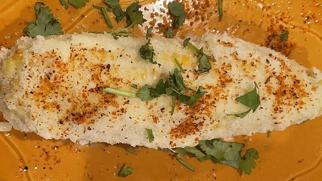 Elote · Corn on the cob with mayonnaise, cheese, chili powder, and garnished with cilantro.