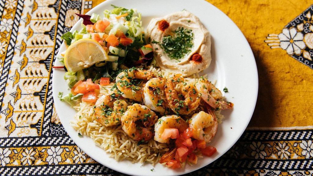Grilled Jumbo Shrimp · Grilled jumbo shrimp served with basmati rice, hummus, green salad, pita bread and tartar sauce.