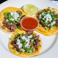 Cantina Tacos · Three tacos on a corn tortilla topped with cilantro and onions, lime wedge and salsa on the ...