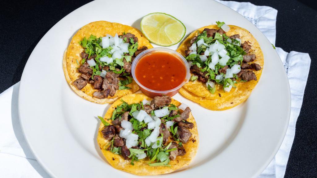 Cantina Tacos · Three tacos on a corn tortilla topped with cilantro and onions, lime wedge and salsa on the side.
