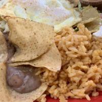 Chilaquiles Mexican Style · Tortilla chips smothered with jack cheese and homemade spicy sauce, topped with two eggs coo...