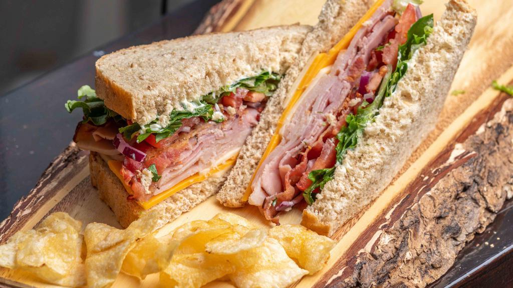 Café Club · Sliced turkey and ham, bacon, Cheddar and Swiss cheese, lettuce, tomato, onion, and mayonnaise.
