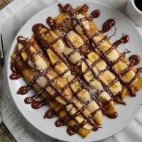 Nuttin Honey Crepes · Fresh sliced bananas and creamy nutella rolled into our delicate crepes then dusted with pow...