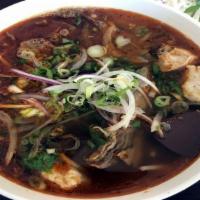 Spicy Lemongrass Bun Bo Hue · Thick rice noodles in beef and spicy lemongrass broth. Beef, tendon, pork patty and house-ma...