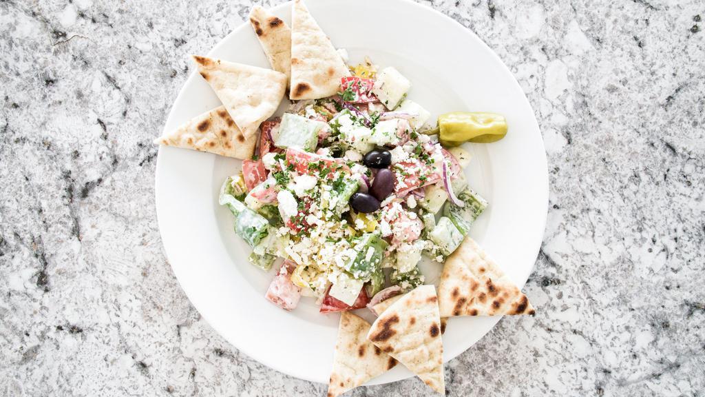 Horiatiki Salad · Tomatoes, cucumbers, red onions, green peppers, feta cheese, kalamata olives and served with a creamy vinaigrette dressing.