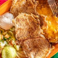 Chuletas Rancheras · Two grilled boneless pork chops served with papas rancheras covered with cheese, served with...