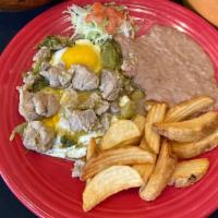 Huevos Rancheros Con Carne De Puerco · Gluten-free. Two eggs sunny side up on a fried tortilla, topped with spicy pork sautéed in y...