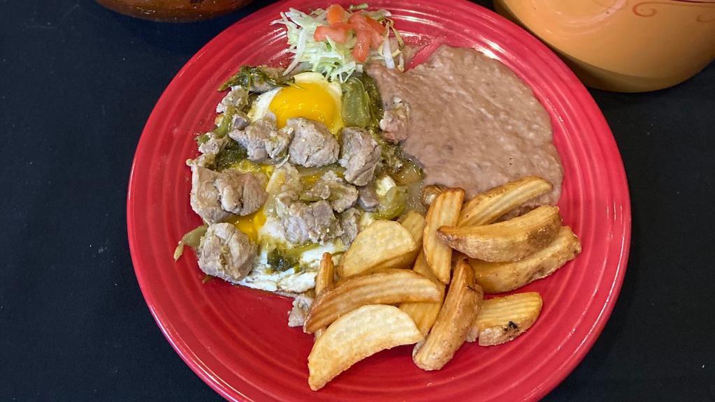 Huevos Rancheros Con Carne De Puerco · Gluten-free. Two eggs sunny side up on a fried tortilla, topped with spicy pork sautéed in your choice of red or green chile sauce. Served with potatoes, refried beans and either corn or flour tortillas.