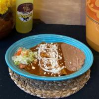 Enchiladas De Mole · Two chicken enchiladas rolled in our own mole sauce, topped with Mexican white cheese & onio...