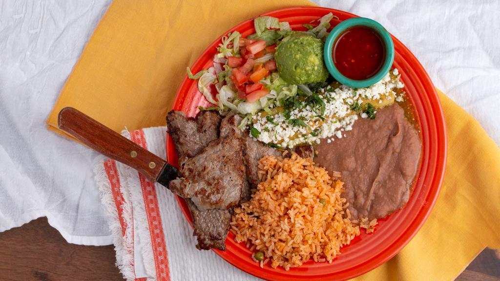 Carne A La Tampiqueña · Gluten free. A 4oz ribeye steak served with a salsa picante & one chicken enchilada topped with green chile verde sauce, Mexican white cheese & cilantro. Served with sopa & your choice of refried beans or black beans, fresh guacamole & corn or flour tortillas.
