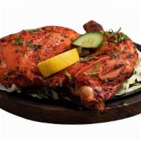 Tandoori Chicken · Chicken marinated in homemade curd with herb and mild spices then cooked in clay oven. Serve...