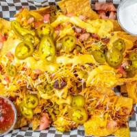 Tavern Nachos · House-made tortilla chips piled high with two cheeses, tomato, jalapenos, and fire roasted c...