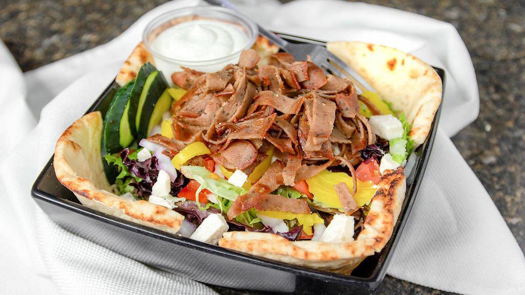 Gyro Salad · Grilled gyro meat, diced tomatoes, Feta cheese, cucumbers, banana peppers, and red onion served over mixed salad greens. Pita points and house-made tzatziki dressing on the side.