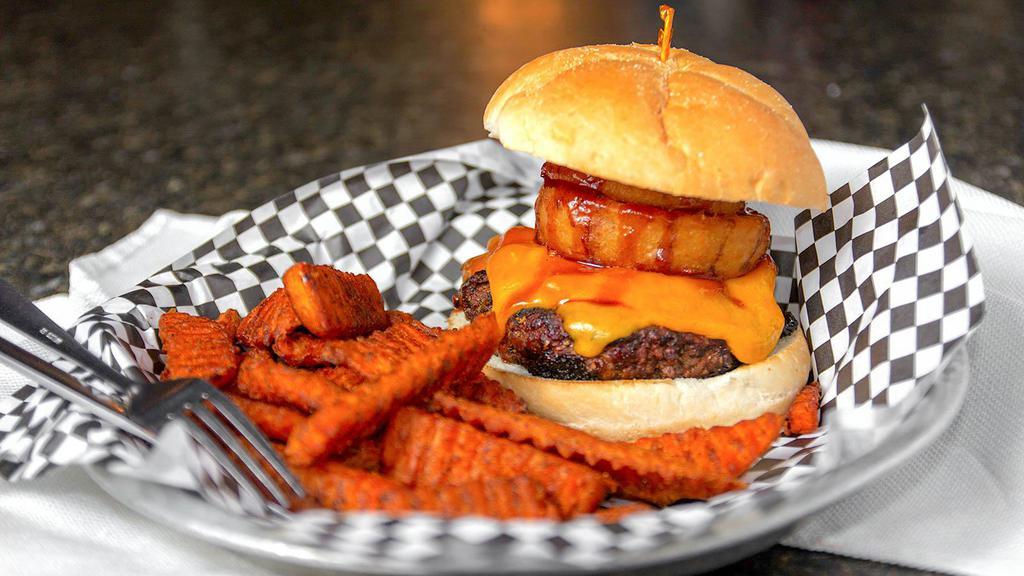 Cowboy Burger · Cheddar cheese, smoked bacon and our signature BBQ sauce, topped with onion rings.