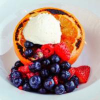 Grapefruit Brulee · Texas ruby red grapefruit, caramelized sugar, fresh berries, and whipped cream.