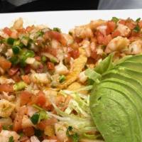 Tostadas De Ceviche · Cooked shrimp, slaw with tomatoes, onions, chile, cilantro, and avocado, served on three cri...