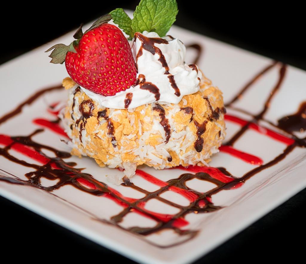 Fried Ice Cream · Fried rice crispy vanilla ice cream coats with corn flakes coconut topped with whipped cream and strawberries.