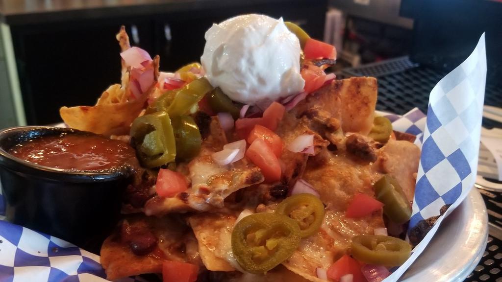 T&T Nachos · house chili with pepperjack queso, shredded cheddar, tomatoes, onions & pickled jalapenos. topped with sour cream and served with fire roasted salsa. 
Your choice of chips - corn, flour or a mix.