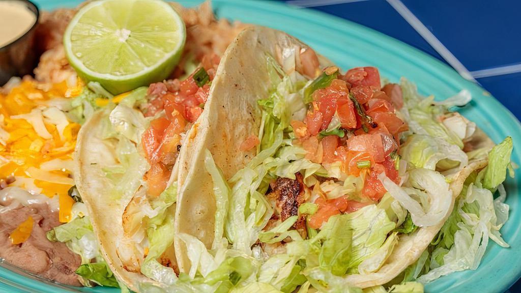 Fish Tacos · Two tacos filled with seasoned tilapia and our own special sauce on soft corn tortillas. Served with rice and beans. No substitutions please.