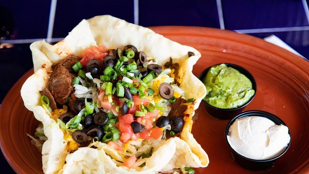 Taza De Carne Salad · A tortilla bowl filled with shredded beef, tomatoes, onions, lettuce, and shredded cheese. Garnished with sour cream and guacamole.