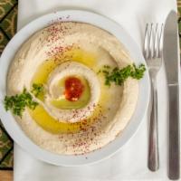 Hummus · Made with puréed chickpeas, tahini and lemon juice, served with pita.