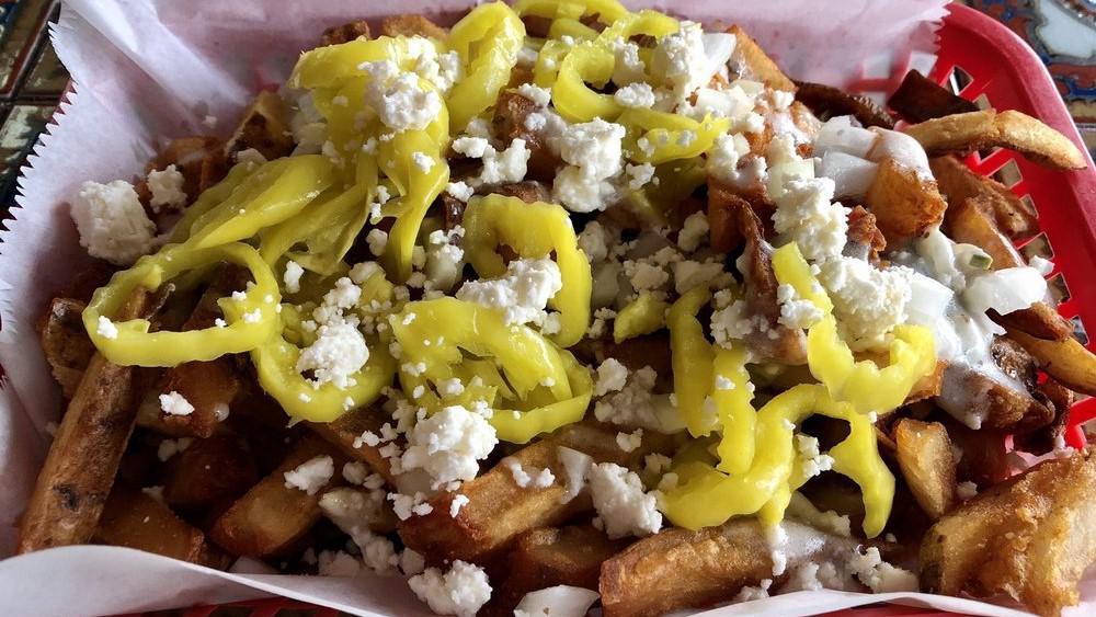 Macedonian Fries · Our hand-cut fries smothered in our creamy Macedonian dressing topped with feta cheese crumbles, diced onions, and banana peppers