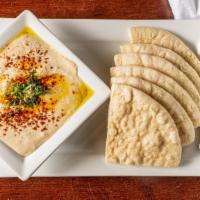 Hummus · Chickpeas pureed with tahini sauce, garlic and lemon juice, served with warm pita bread.