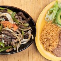Fajitas · Strips of grilled meat, cooked with onions, bell peppers, and tomatoes served with rice, bea...