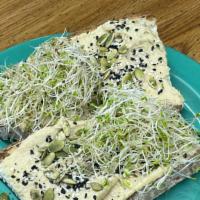 Seeded & Sprouted Hummus Toast · 2 pieces of toast with our homemade Hummus topped with Pumpkin, Sunflower and Sesame Seeds, ...