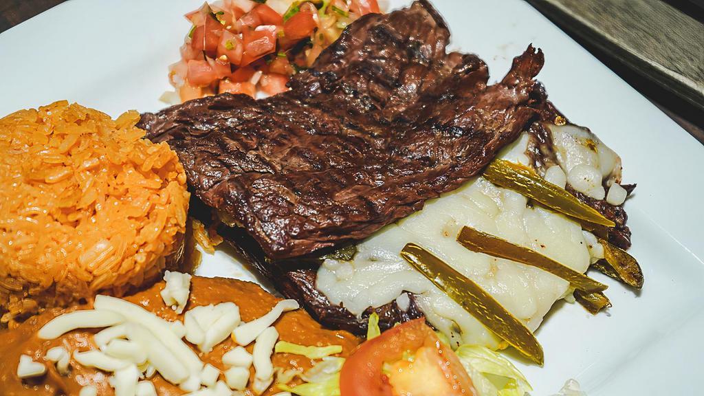 Asada Monarca · Charbroiled steak topped with melted cheese and jalapeño peppers. served with rice , beans and guacamole salad.